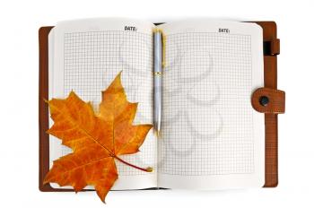 Opened notebook with a red maple leaf isolated on white background