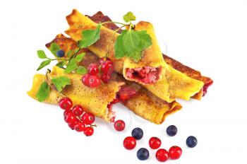 Pancakes with berry filling, two brushes of red currant and blueberry twig with green leaves isolated on white background