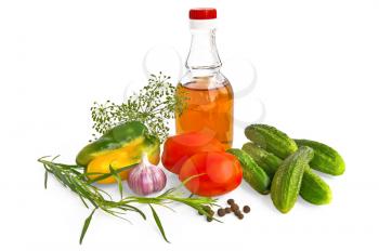 Two red tomatoes, a bottle of apple cider vinegar, a few green cucumber, a pepper, garlic, peas sweet pepper, dill and tarragon isolated on a white background