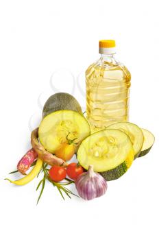 Cut zucchini, red and yellow tomatoes, green beans, garlic, a sprig of green tarragon, a bottle of vegetable oil is isolated on a white background