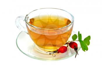 Tea in a glass cup, berries and green leaves of wild rose isolated on white background