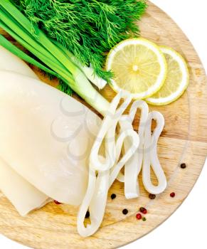 Whole and sliced squid rings, lemon, dill, different peppers, green onions on a wooden board isolated on white background