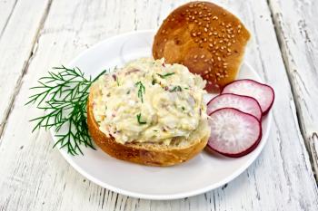 Appetizer of radish, dill, eggs and cheese on bread in a white plate on a wooden boards background
