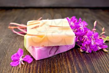 Two bars of homemade soap with fireweed flowers on the background of wooden boards