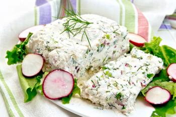 Terrine of cottage cheese and radish with dill, chives, salad in white plate, napkin on a light wooden planks