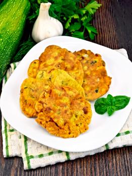 Indian chick-pea flour flatbreads with zucchini and fresh herbs in a plate on a napkin, garlic and parsley on a wooden board background