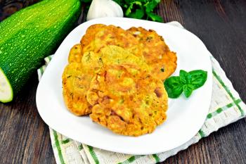 Indian chick-pea flour flatbreads with zucchini and fresh herbs, basil in a bowl on a napkin, garlic and parsley on a wooden board background