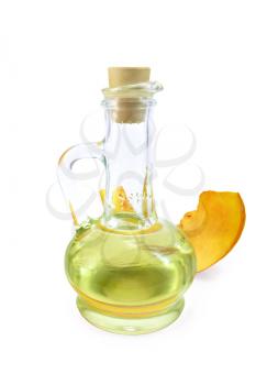 Pumpkin oil in a glass decanter with a vegetable slice isolated on a white background