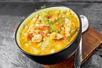 Ragout of zucchini, minced chicken and tomatoes with herbs in a bowl on dark wooden board background