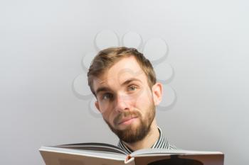 Surprised hipster man reading a book