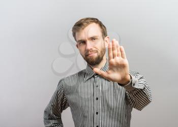 Closeup portrait of surprised helpless young man raising hand up to say no stop right there, isolated on white background. Negative emotion facial expression feelings, signs symbols, body language