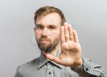 Closeup portrait of surprised helpless young man raising hand up to say no stop right there, isolated on white background. Negative emotion facial expression feelings, signs symbols, body language