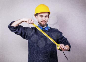 young builder with yellow tape measure