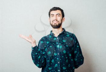 young attractive business man showing blank copy space above palm hand for client to add product or text, looking happy and excited