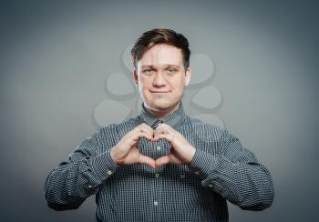 man hands forming a heart on gray background