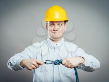 Construction worker holds a rope and carbine. Full length studio shot isolated .