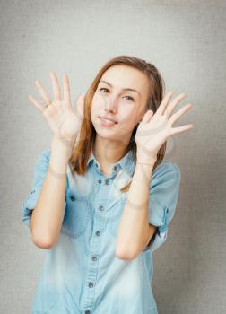 female gesture surprised hands up. isolated on gray background