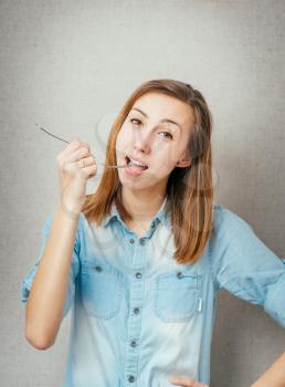 woman with a fork eats. isolated on gray background