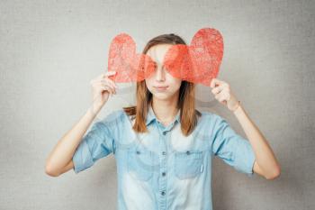 girl holding two paper hearts