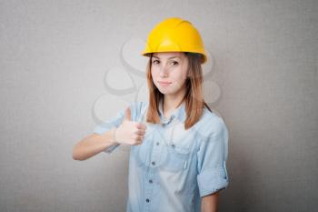 girl in the construction helmet showing thumbs up