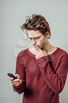 A man reading bad news on the phone. On a gray background.
