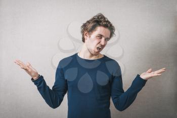 Man angry, shouts, lifting his hands up. Gray background
