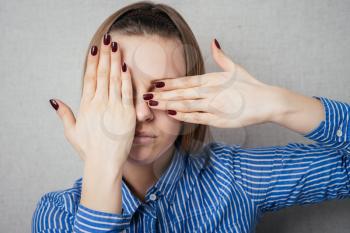 girl covers her face with her hands