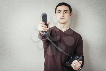 Man holding a landline telephone receiver 