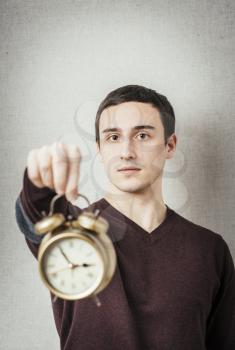young man holding an alarm clock