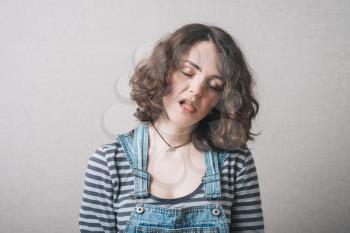 the girl is very tired, dressed in overalls