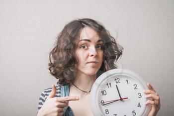 Woman showing on the clock. Gray background