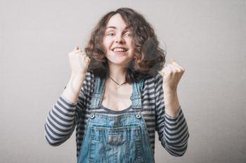 Excited happy success young woman with fists up