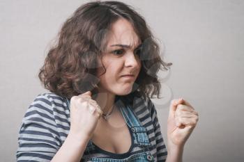 angry woman threatening the fist over grey background