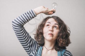beautiful woman holding up a light bulbs in her hand