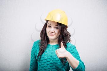 portrait of a girl in the construction helmet shows OK