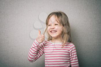 Beautiful little girl inshows finger as sign that everything is fine