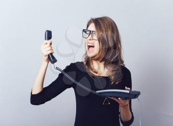 Woman with office or home phone. On a gray background.