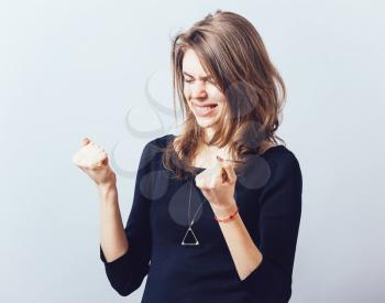 Excited young woman with fists up