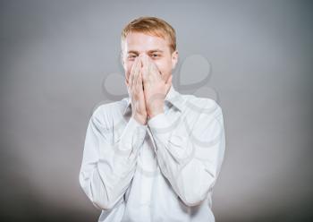 Closeup portrait of laughing excited smiling happy man covering mouth pointing at you with index finger, isolated on white background. Positive human emotion facial expression feeling, body language