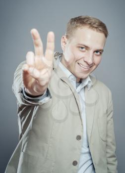 business man in a suit giving the victory sign