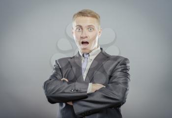 young handsome man surprised isolated over gray background