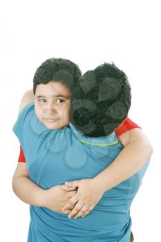 Portrait of a young boy hugging his father against white background 