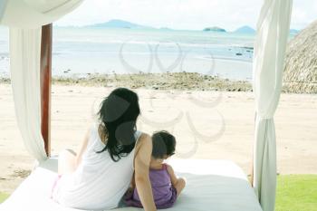 mom with a child watching the beach on the bed