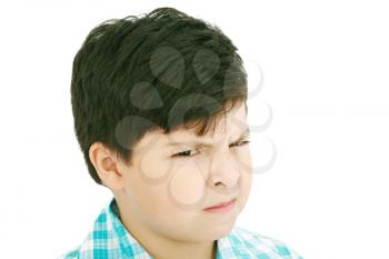 Close-up portrait of angry little boy isolated on white background 
