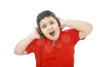 Portrait of a sweet young boy listening to music on headphones against white background 
