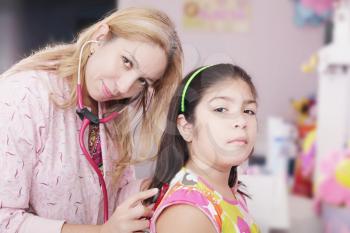 Pediatrician examining little girl with stethoscope 
