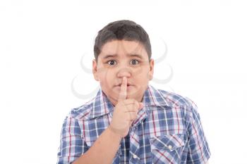 Portrait of beautiful little boy with silence gesture over white background 