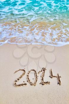 New 2014 year figures written on the sand seasonal background.