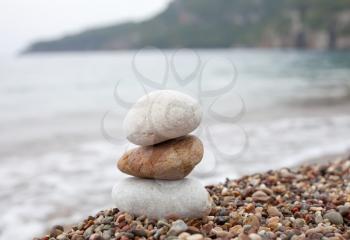 balanced stone pyramid standing on the beach of sea
