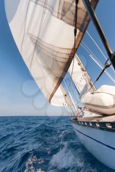 Sailing yacht on the race in blue sea
